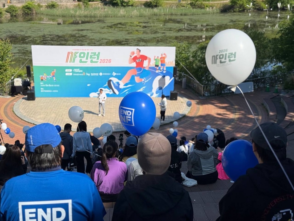 ENDNF 풍선을 든 참가자들이 NF인런 2026 무대 앞에 모여 있는 모습